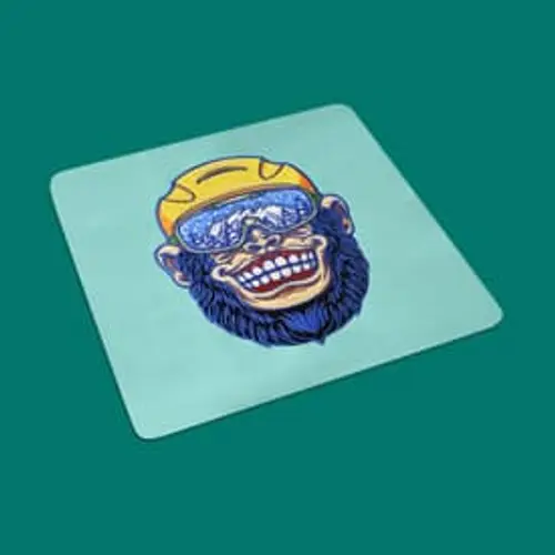 Lustiges Stickmotiv: Grinsender Affenkopf mit Brille und Helm. Perfekt für coole Mode und trendige Accessoires.